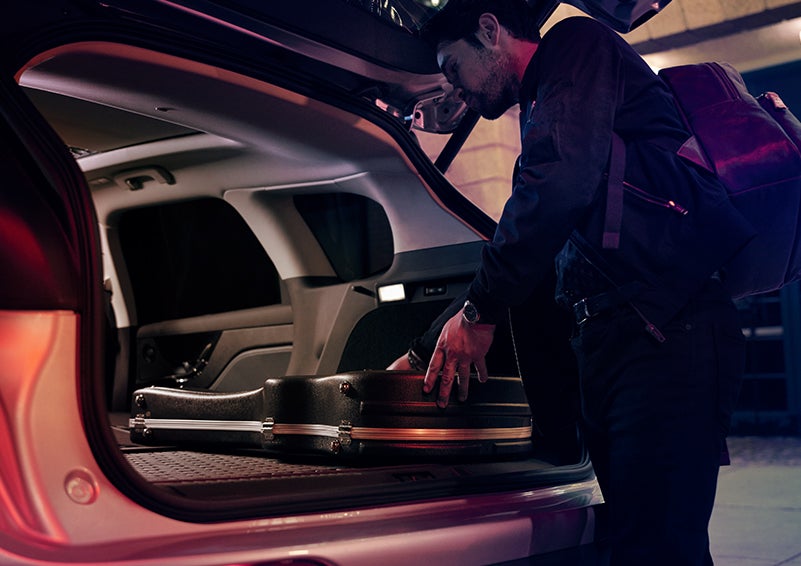 A man is shown loading cargo into the rear of a 2023 Lincoln Corsair® SUV with the second-row seats folded flat. | Bergstrom Lincoln of Neenah in Neenah WI