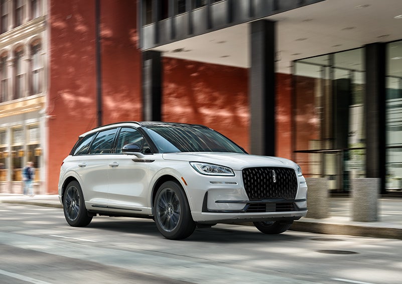 The 2024 Lincoln Corsair® SUV with the Jet Appearance Package and a Pristine White exterior is parked on a city street. | Bergstrom Lincoln of Neenah in Neenah WI