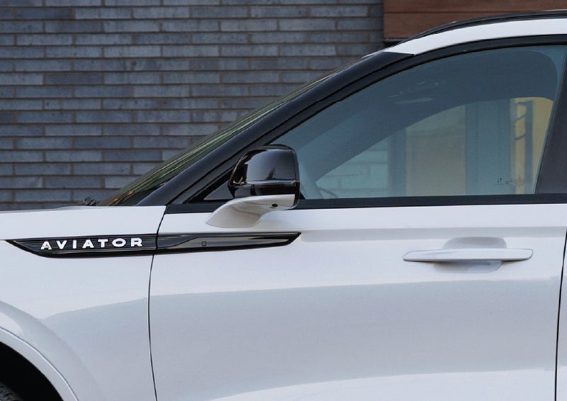 The driver’s side door and fender badging of a white 2026 Lincoln Aviator® SUV are showcased. | Bergstrom Lincoln of Neenah in Neenah WI