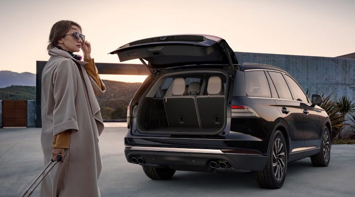 A woman approaches a 2026 Lincoln Aviator® SUV with its rear liftgate open. | Bergstrom Lincoln of Neenah in Neenah WI