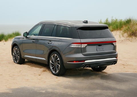 A 2027 Lincoln Aviator® SUV is parked next to sand dunes. | Bergstrom Lincoln of Neenah in Neenah WI
