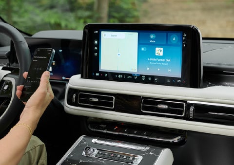 A person pairs thier phone with the center touchscreen of a 2027 Lincoln Aviator® Black Label™ SUV | Bergstrom Lincoln of Neenah in Neenah WI