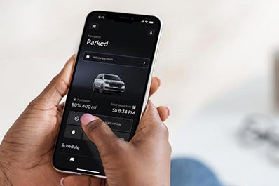 A woman holding a phone viewing the Lincoln app.